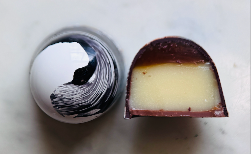 A warm cinnamon caramel layered with silky vanilla ganache, creating a smooth, spiced sweetness wrapped in dark and milk chocolate
